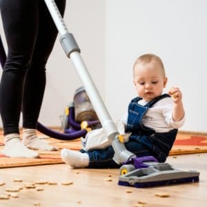 Image of an adult hoovering around a baby